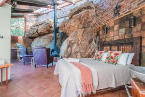 帕雷斯Thabela Thabeng的一间卧室设有一张床和一面岩石墙