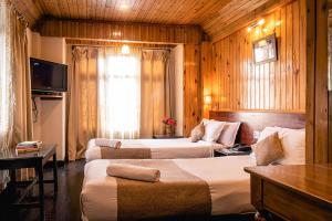 大吉岭珠峰别墅的酒店客房,设有两张床和一张沙发
