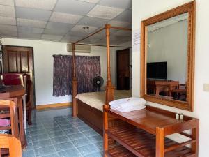 湄宏颂The Creek Garden Resort Huainamrin ห้วยนำ้ริน的一间卧室配有一张带镜子的床和一张书桌