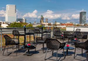 柏林SANA柏林酒店的一张桌子和椅子,位于一个享有城市天际线的阳台