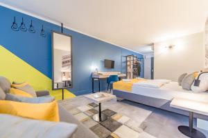 布达佩斯Impulso Fashion Hotel的酒店客房,设有两张床和一张沙发