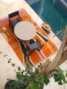 马拉喀什Riad Dar Massai的桌椅和游泳池的顶部景致