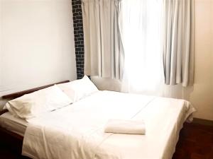 彭亨Selesa hill homestay的卧室配有白色的床和窗户