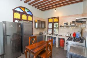 南威Majani Breeze的厨房配有桌子和不锈钢冰箱。