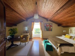 VárzeaVilla Várzea - Charming Suite的一间卧室设有一张带木制天花板的大床
