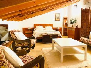 纳瓦尔卡内罗Casa Rustica con Encanto的卧室配有一张床和一张桌子及椅子