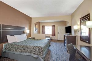 WestfieldDays Inn & Suites by Wyndham Houston North - Spring的配有一张床和一台平面电视的酒店客房