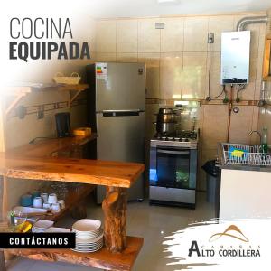 拉斯特朗卡斯奥拓科迪勒拉山林小屋的厨房配有冰箱和带盘子的桌子
