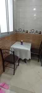 拉巴特Dar Ba Brahim的一张桌子,上面有两把椅子和一个紫色花瓶