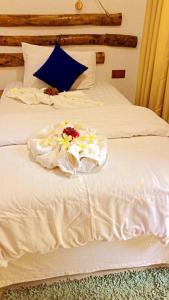 古雷德胡Rangali Etos Guraidhoo的一张白色的床,上面有鲜花