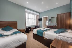 伦敦King Solomon Hotel- Golders Green的酒店客房配有两张床和一张书桌