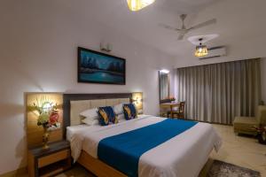 桑戈尔达Lotus & Orchid Villas by Ramnath Homes的一间卧室配有一张带蓝白色床单的大床