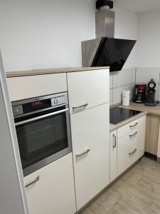 奥尔珀Fewo Linde的厨房配有白色橱柜和炉灶烤箱。