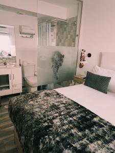 多列毛利诺斯Torremolinos Suite的一间卧室设有一张床和一个玻璃淋浴间