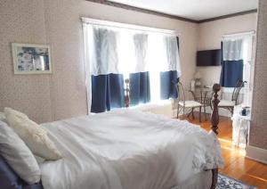 海斯The Bissing House的卧室设有一张白色大床和一扇窗户。