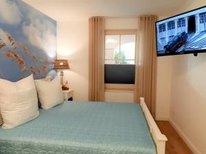 奥斯赛拜-屈隆斯博恩Appartementhaus Laguna的一间卧室配有一张床和一台平面电视