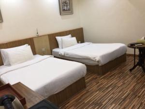 巴格达帕姆酒店的酒店客房设有两张床和一张桌子。