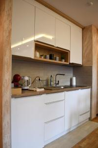 兹拉蒂博尔Apartman Dream的厨房配有白色橱柜和水槽