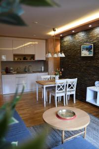 兹拉蒂博尔Apartman Dream的厨房以及带桌椅的起居室。