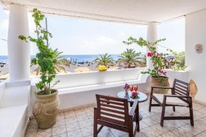 斯特龙博利Hotel Ossidiana Stromboli Center的阳台配有桌椅,享有海滩美景