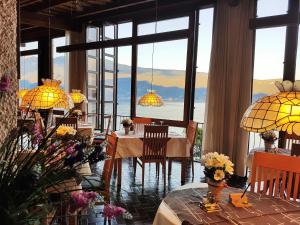 加尔尼亚诺帕拉吉纳酒店的用餐室配有桌椅和大窗户