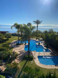 卡拉德米哈斯ARRUZAFA PLAYA Beachfront apartment La Cala de Mijas的享有棕榈树泳池和大海的空中景致