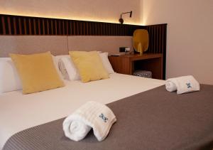塞维利亚ISA Sevilla Suites的酒店客房,配有带毛巾的床