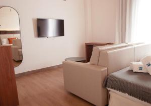 塞维利亚ISA Sevilla Suites的客厅配有椅子和镜子