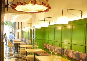 塞维利亚ISA Sevilla Suites的一间拥有绿色墙壁的餐厅里的一排桌椅