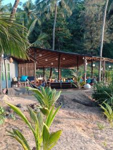 卡纳科纳Bamboo Yoga Retreat的海滩上带凉亭的度假村