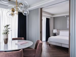雅典雅典君悦酒店 的酒店客房带一张床、一张桌子和椅子