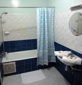马拉喀什Marrakech Hôtel Résidence的蓝色瓷砖浴室设有水槽和淋浴