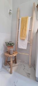 阿尔马达Canto da Rocha Guesthouse的一间带木椅和毛巾的浴室