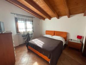 菲乌米奇诺奥拉公寓的一间卧室配有一张带橙色床头板和窗户的床。