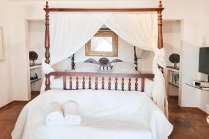 古斯塔维亚Viewstar的卧室配有带白色床单的天蓬床