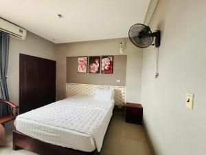 荣市Hoang Ngan 1 Hotel - TP. Vinh的卧室配有白色的床和风扇