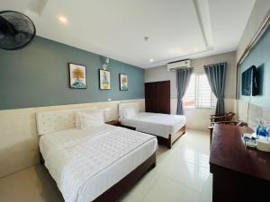 荣市Hoang Ngan 1 Hotel - TP. Vinh的酒店客房配有两张床和一张书桌