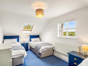克利夫登Sycamore Cottage的一间卧室设有两张床和窗户。