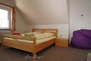 博尔库姆Haus-Koenigsduene-I-4的一间卧室配有一张床、一个紫色枕头和一个窗户