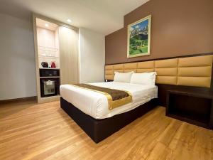 马六甲霍尔马克皇冠酒店的一间卧室设有一张大床和一个壁炉