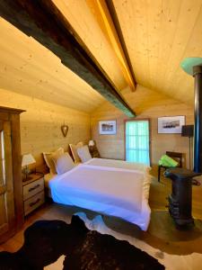 克莱恩 蒙塔纳勒马耶德克伦比尔度假屋的木制客房内的一间卧室配有一张大床