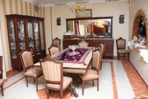 开罗Kenzy guest house的一间带桌椅和镜子的用餐室