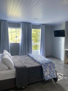 格拉玛多Vista da Serra.的一间卧室配有一张带蓝色窗帘的大床