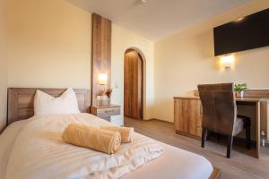 瓦兹阿勒伯格乡村别墅酒店的一间卧室配有一张床、一张桌子和一把椅子