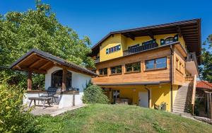 瓦兹阿勒伯格乡村别墅酒店的黄色的房屋,设有甲板和庭院