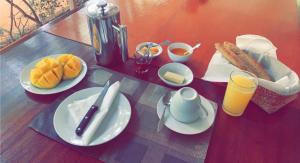 博博迪乌拉Villa Bobo的餐桌上放有食物和橙汁