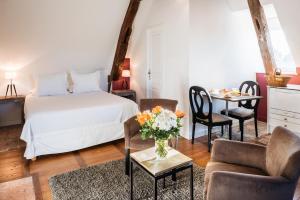 博讷拉梅森德斯科提尼斯酒店的卧室配有一张床和一张桌子及椅子