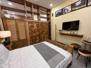 胡志明市Anam Homestay的一间卧室配有一张床和一台平面电视