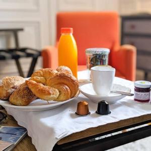 博讷拉梅森德斯科提尼斯酒店的一张桌子,上面放着一盘糕点和一杯咖啡