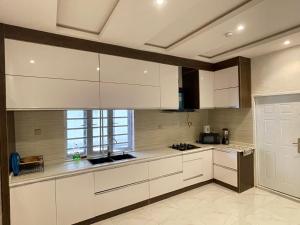 AbeokutaVilla Sofia的厨房配有白色橱柜和窗户。